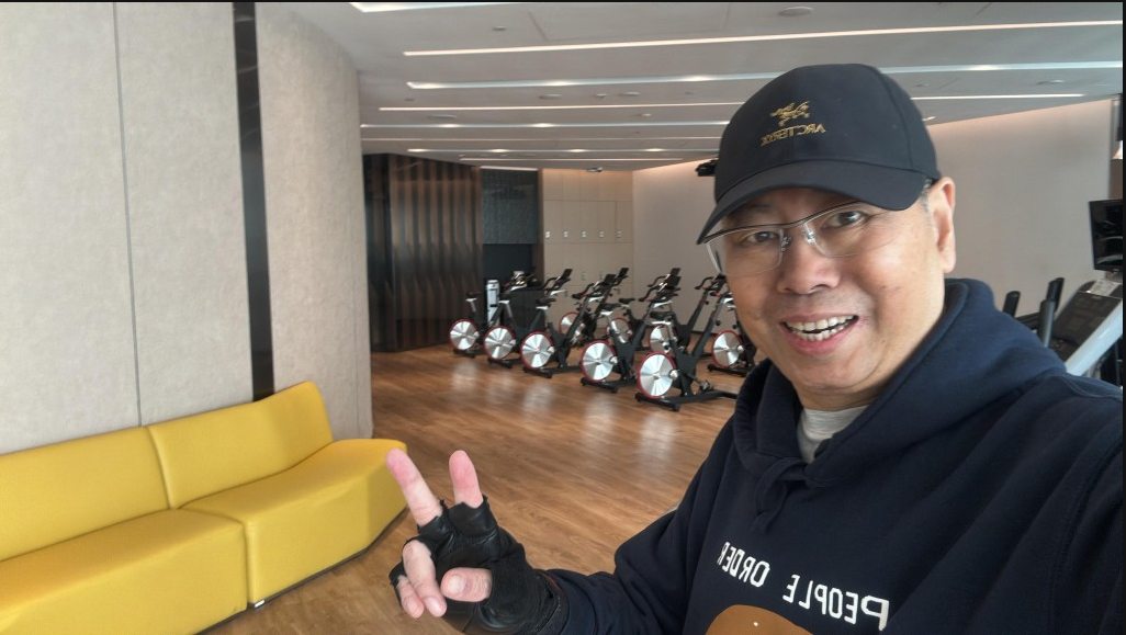 Mr. Lu at the gym, smiling with a peace sign